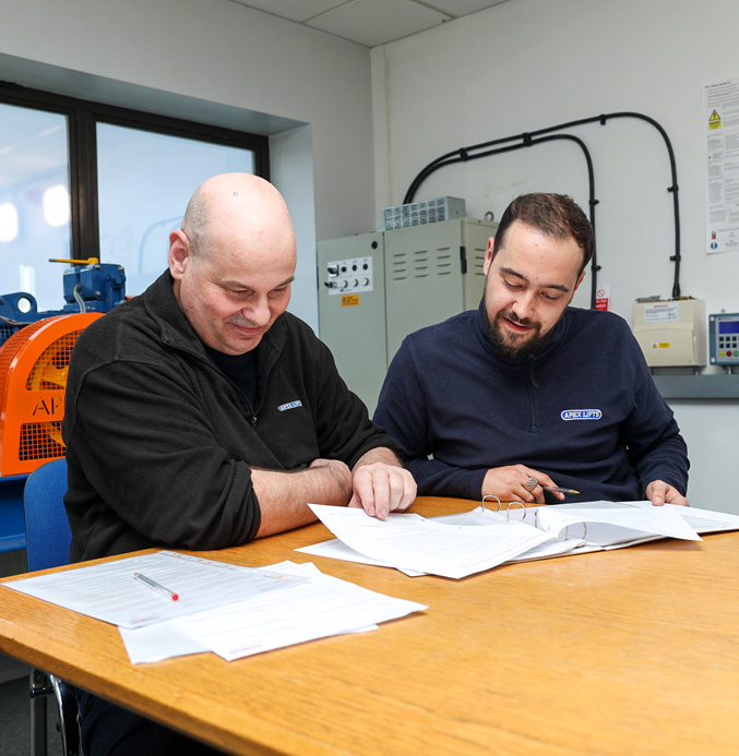 Two engineers reviewing documents at the Apex academy