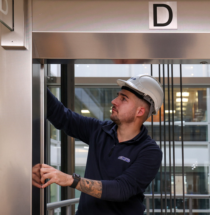 apex-engineer-holding-lift-door-frame Apex engineer holding a lift door frame open