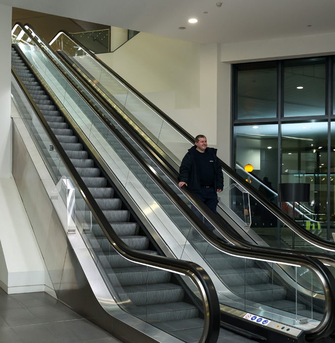 Apex engineer travelling down an escalator