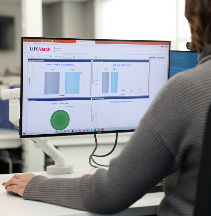 Woman sat at a desk looking at LiftWatch statistics