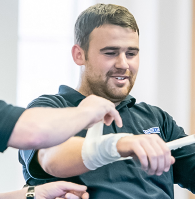 Apex employee having his wrist bandaged for health and safety training