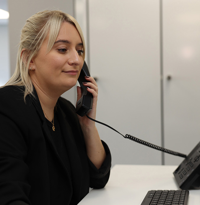lady-on-phone-call-desk Lady on the phone at a call desk