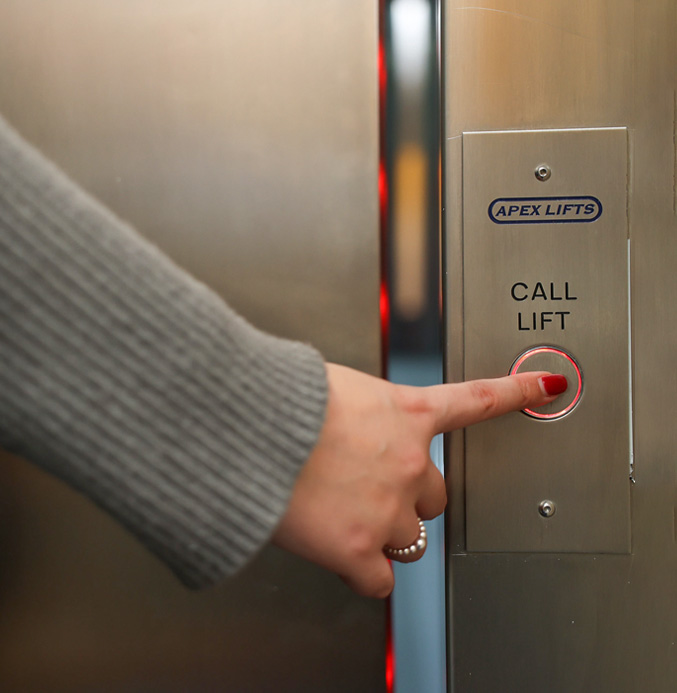 Woman's finger pressing a call lift button